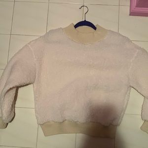 This fluffy white sweater is made of wool and is very fluffy and warm.